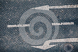 Direction arrow and street sign on handmade stone pavement in Lisbon - Traditional Portuguese handmade mosaic background