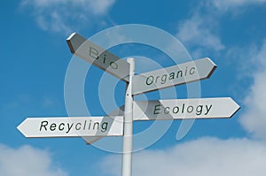 direction panels with different ecological choices on cloudy sky background