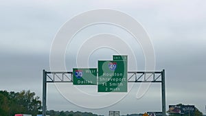 Direction signs on the highway to Dallas and Houston - POV driving by