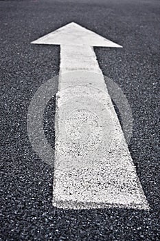 Directional arrow sign on asphalt