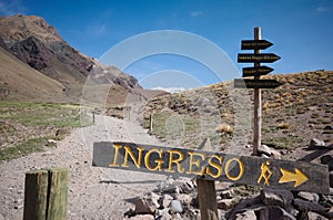 Directional sign with arrow pointing where is entrance on hiking trail in Aconcagua National Park, Andes Mountains, Argentina.