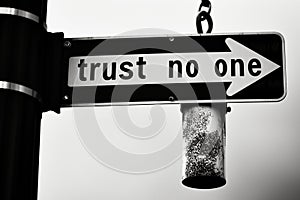 Directional sign with inscription 'trust no one', arrow pointing right, black and white photo