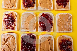 Directly above shot of bread slices with preserves and peanut butter arranged alternatively
