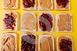 Directly above shot of bread slices with preserves and peanut butter arranged alternatively photo