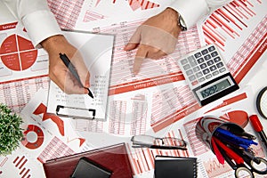 Directly above view of businessman working and calculating finance, reads and writes reports. Business financial accounting