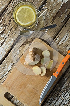 Directly above view of gingers on cutting board by tea over weathered table