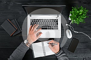 Directly above view of human hands typing on laptop.