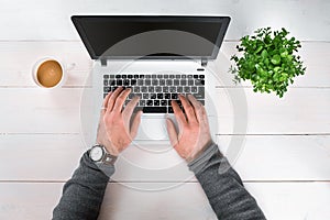 Directly above view of human hands typing on laptop.