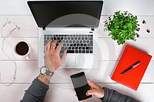 Directly above view of human hands typing on laptop.