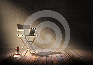 Director`s chair with clapper board and megaphone in dark room scene with spotlight light