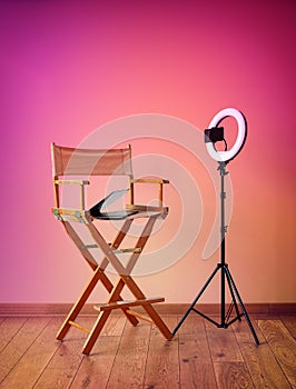 Director\'s chair on colorful background with equipment for recording