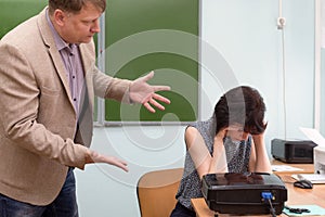 The director scolds the teacher for an unfulfilled task and throws