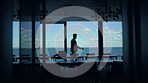 Director silhouette walking sea panoramic window. Leader boss waiting in hotel