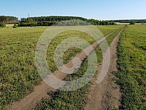 Dirt country road in a green field