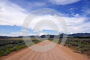 Dirt Desert Road and Blue cloudy Sky