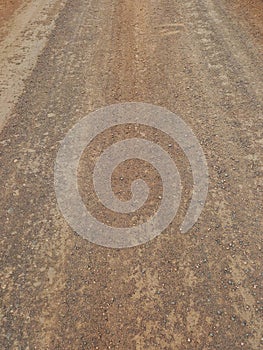 Dirt and gravel background. Unpaved road. Cracked and abrupt terrain. Dryness and climate change