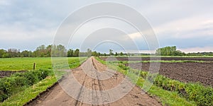 Dirt oad along farmland in the flemsh countryside