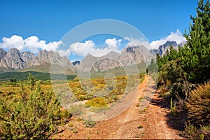 Dirt red road towards majestic mountains