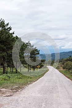 Dirt road along the hill with the traffic sign