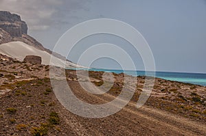 Dirt road along the ocean. Emerald water, pristine beaches, wild rocky shores. Amazing landscape. Yemen. Socotra.
