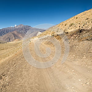 Dirt road through arid mountain wastelands.