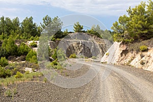 Dirt road with car tracks in desert greek landscape.