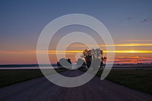 Dirt road deep in the forest. A sunset