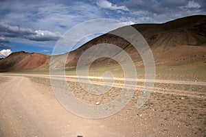 A dirt road going through the steppe at the slope of the Red Mountain