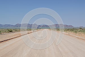 Dirt Road Highway in a Desert Landscape with Mountains in Namibia