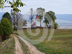 Dirt road leading to a small catholic church