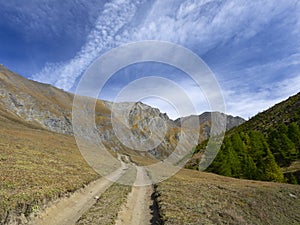 Dirt road leads to the peaks of the mountains