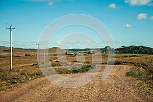 Dirt road passing through rural lowlands and ranch