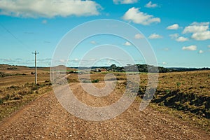 Dirt road passing through rural lowlands and ranch