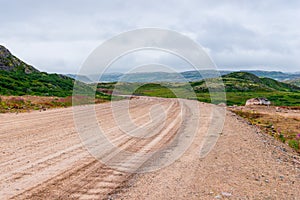 Dirt road in a polar landscape with granite stones