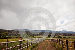 Dirt road on a ranch with a cloudy sky