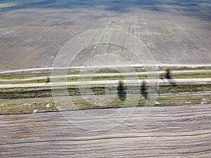 Dirt road between two plowed fields, aerial view. Agricultural land