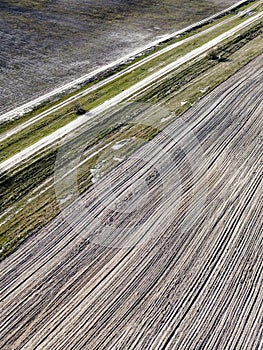 Dirt road between two plowed fields, aerial view. Agricultural land