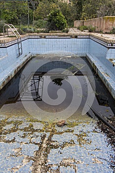 A dirty and abandoned pool with little water, abandoned pool, abandoned swimming pool, ruined pool
