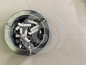 Dirty ashtray full of cigarette butts