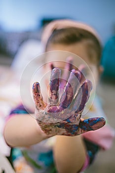 Dirty baby hands after color painting at home