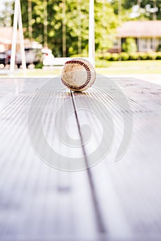 Dirty Baseball Sitting on a Metal Table at a Neighborhood Park