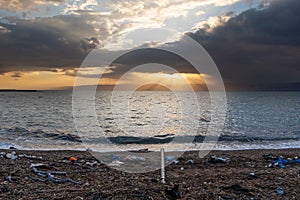 Dirty beach full of trash with waste water pipe to the ocean