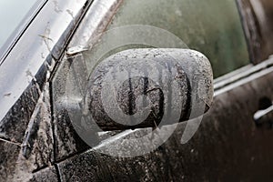 Dirty black car. Very dirty car mirror. Close up