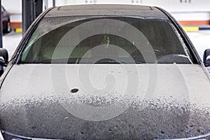 Dirty black car with wiped windshield wipers. photo