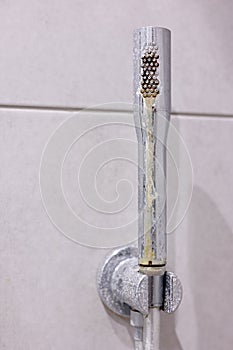 Dirty calcified shower chrome mixer tap, faucet with limescale on it, plaque from hard water. Steel plumbing with fungus
