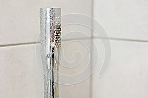 Dirty calcified shower chrome mixer tap, faucet with limescale on it, plaque from hard water. Steel plumbing with fungus