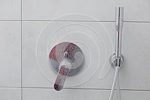 Dirty calcified shower mixer tap, faucet with limescale on it, plaque from water, Chrome-plated shower, close up photo