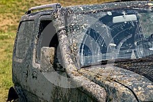 A dirty car covered with a layer of swamp spray as a result of off-road driving.