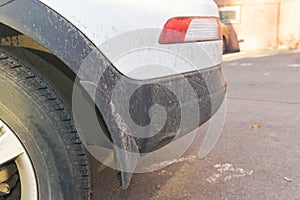 Dirty car side. Fragment of a dirty SUV. Dirty rear wheel and bumper of the off-road car with swamp splashes on a side panel.