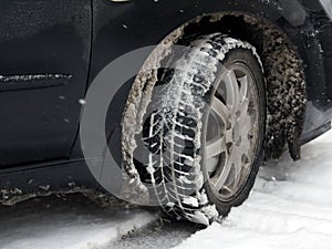 Dirty car tire with snow